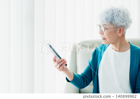 Senior woman surprised by nuisance phone calls Senior woman surprised by nuisance phone calls 140899902