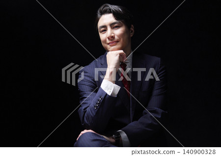 Portrait of a businessman in his 30s, in darkness, looking directly at the camera. Portrait of a businessman in his 30s, in darkness, looking directly at the camera. 140900328