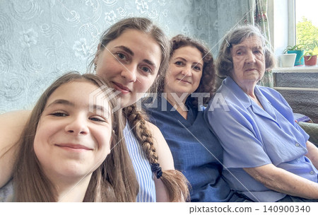 Four generations of women smiling together at home, family love and close connection Four generations of women smiling together at home, family love and close connection 140900340