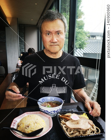 A man eating tsukemen (dipping noodles) and fried rice at a public bathhouse. A man eating tsukemen (dipping noodles) and fried rice at a public bathhouse. 140900960