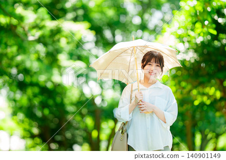 拿著遮陽傘的婦女在公園 140901149