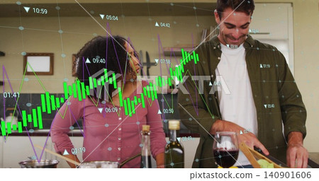 Preparing couple in pink top, olive shirt chopping on cutting board in home kitchen, data overlay Preparing couple in pink top, olive shirt chopping on cutting board in home kitchen, data overlay 140901606