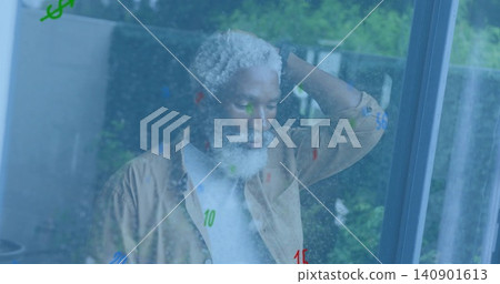 Standing senior man wearing light beige jacket scratching head by window glass at home with numbers 140901613