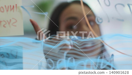 Pointing adult woman wearing dark top gesturing at glass board in office with markers sticky note Pointing adult woman wearing dark top gesturing at glass board in office with markers sticky note 140901628