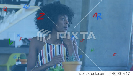 Sitting woman in sleeveless striped multicolor dress touching terracotta pot with cactus in cafe Sitting woman in sleeveless striped multicolor dress touching terracotta pot with cactus in cafe 140901647