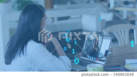 Leaning woman in white shirt attending remote call at wooden table, with laptop and color swatches Leaning woman in white shirt attending remote call at wooden table, with laptop and color swatches 140901648