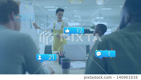 Pointing leader in yellow overalls guiding team in meeting room with flipchart marker social icons 140901838