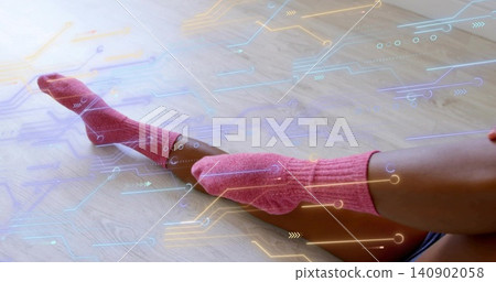 Displaying woman's legs wearing pink knit socks, dark shorts on light wood floor, circuit graphics 140902058