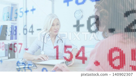 Consulting doctor taking notes at clinic desk with stethoscope and clipboard, patient in pink top Consulting doctor taking notes at clinic desk with stethoscope and clipboard, patient in pink top 140902307