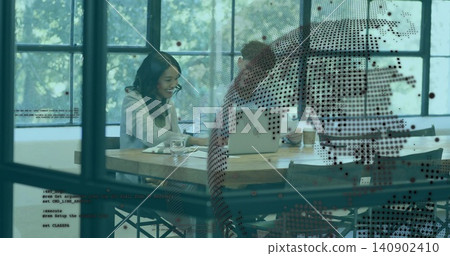 Working pair in business-casual reading papers checking phone in office, with laptop, dotted glass Working pair in business-casual reading papers checking phone in office, with laptop, dotted glass 140902410