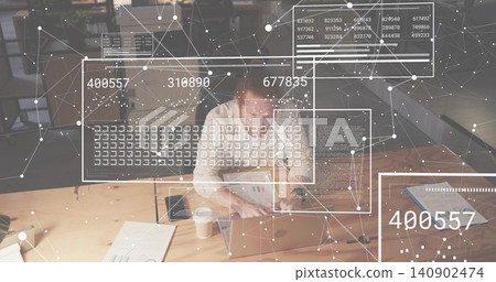 Typing woman in light shirt using silver laptop, reviewing documents in office with data and phone 140902474