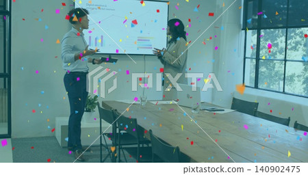 Presenting coworkers in business-casual gesturing at wall screen in meeting room, with confetti 140902475