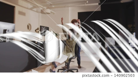 Raising arms, woman in light jacket on swivel chair, coworker reaching behind screens in office Raising arms, woman in light jacket on swivel chair, coworker reaching behind screens in office 140902503