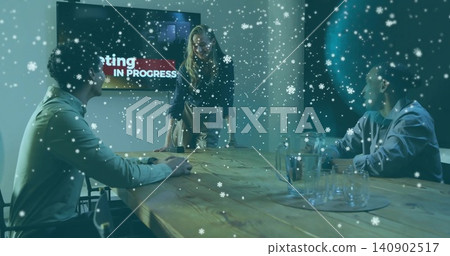 Leaning leader wearing blazer guiding talk at wooden table, showing IN PROGRESS screen and pitcher 140902517