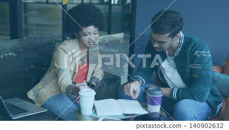 Leaning colleagues pointing at open notebook on glass table in lounge, wearing blazer and jacket Leaning colleagues pointing at open notebook on glass table in lounge, wearing blazer and jacket 140902632