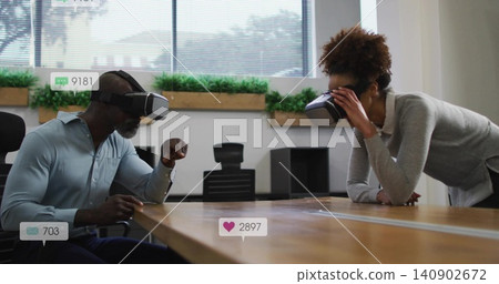 Gesturing man in blue shirt and woman adjusting VR headsets at office meeting table social overlays Gesturing man in blue shirt and woman adjusting VR headsets at office meeting table social overlays 140902672