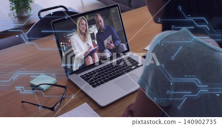 Watching viewer wearing gray tee facing open laptop during home office meeting, with notepad Watching viewer wearing gray tee facing open laptop during home office meeting, with notepad 140902735