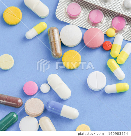 Seamless pattern of colorful medical pills capsules and tablets flat lay on blue background Seamless pattern of colorful medical pills capsules and tablets flat lay on blue background 140903354