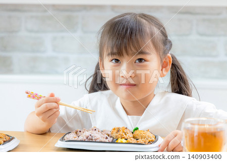 A parent and child enjoying a delivered lunch with smiles; an image of a healthy diet. A parent and child enjoying a delivered lunch with smiles; an image of a healthy diet. 140903400