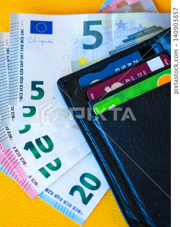Black Leather Wallet with Euro Banknotes and Payment Cards on Bright Yellow Background Close Up Black Leather Wallet with Euro Banknotes and Payment Cards on Bright Yellow Background Close Up 140903857