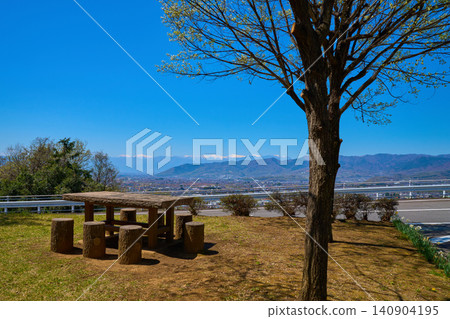 View of the snow-capped Southern Alps and other peaks to the west from a bench on Ushioku Miharashi Hill in Koshu City, Yamanashi Prefecture in spring. View of the snow-capped Southern Alps and other peaks to the west from a bench on Ushioku Miharashi Hill in Koshu City, Yamanashi Prefecture in spring. 140904195