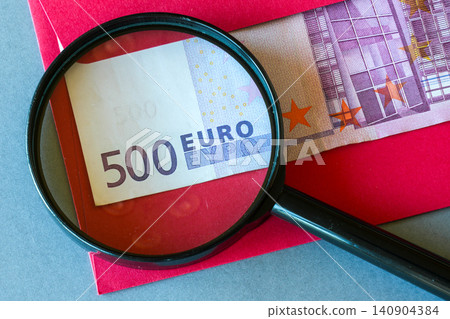 Magnifying Glass Reveals Hidden 500 Euro Cash in Red Envelope Symbolizing Secret Payment and Wealth Concept Magnifying Glass Reveals Hidden 500 Euro Cash in Red Envelope Symbolizing Secret Payment and Wealth Concept 140904384