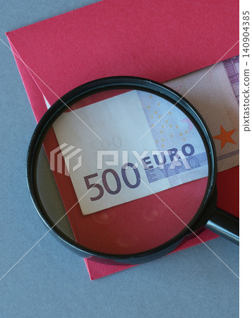 Hidden 500 Euro Banknote in Red Envelope Under Magnifying Glass Symbolizing Secret Cash and Financial Fraud Hidden 500 Euro Banknote in Red Envelope Under Magnifying Glass Symbolizing Secret Cash and Financial Fraud 140904385