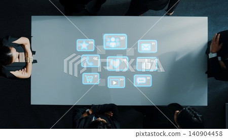 Business Team Collaborating at a Table with Digital Social Media Icons Projected on Surface in a Modern Office Environment. Raster Business Team Collaborating at a Table with Digital Social Media Icons Projected on Surface in a Modern Office Environment. Raster 140904458