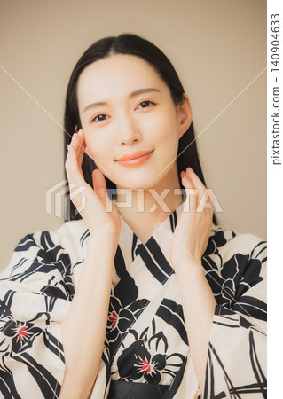 一位身穿浴衣的女子正在護膚。 一位身穿浴衣的女子正在護膚。 140904633