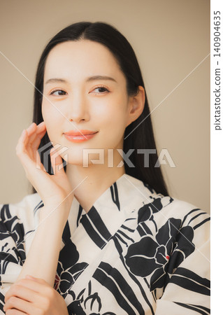 一位身穿浴衣的女子正在護膚。 一位身穿浴衣的女子正在護膚。 140904635