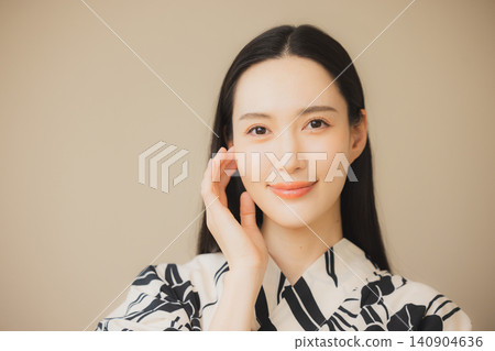 一位身穿浴衣的女子正在護膚。 一位身穿浴衣的女子正在護膚。 140904636