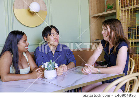 A group of international university students chatting in a cafe. A group of international university students chatting in a cafe. 140904956