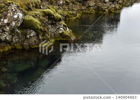 Glacial water filling a rocky volcanic fissure in a mossy rift valley, Iceland Glacial water filling a rocky volcanic fissure in a mossy rift valley, Iceland 140904983