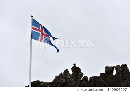 National flag of Iceland against a cloudy sky National flag of Iceland against a cloudy sky 140904997
