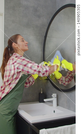 Vertical Video Professional cleaner in uniform tidying bathroom. Cleaning service concept. Vertical Video Professional cleaner in uniform tidying bathroom. Cleaning service concept. 140905305