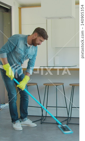 Vertical Video Man is mopping floor at home and having fun. Man, joy and houses concept. Vertical Video Man is mopping floor at home and having fun. Man, joy and houses concept. 140905354