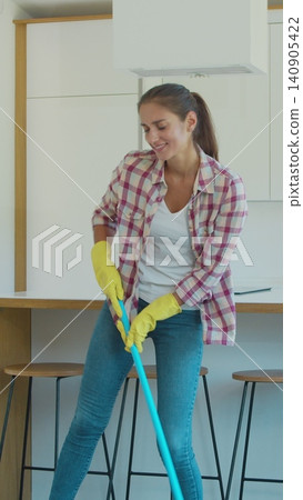 Vertical Video Young woman singing and dancing while cleaning her house. Vertical Video Young woman singing and dancing while cleaning her house. 140905422