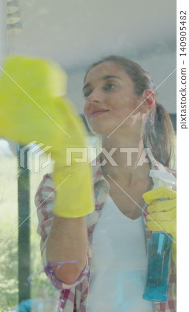 Vertical Video Girl removing cleaning solution from glass with special tool, cleaning service. Vertical Video Girl removing cleaning solution from glass with special tool, cleaning service. 140905482