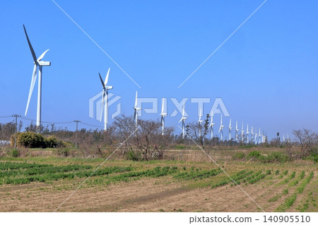 Wind turbines for wind power generation standing near a field in spring Wind turbines for wind power generation standing near a field in spring 140905510