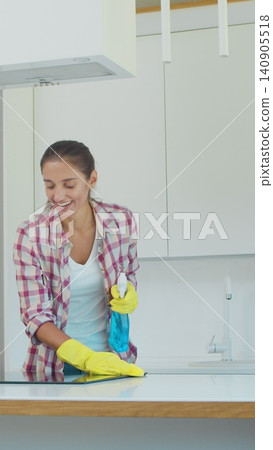Vertical Video Man and woman as a professional cleaners in uniiform having fun during the work on the kitchen. Vertical Video Man and woman as a professional cleaners in uniiform having fun during the work on the kitchen. 140905518