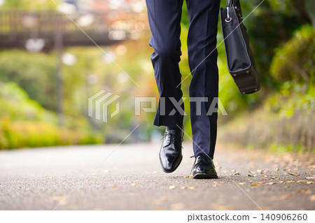 一位二十多歲的商人正在戶外散步。 一位二十多歲的商人正在戶外散步。 140906260