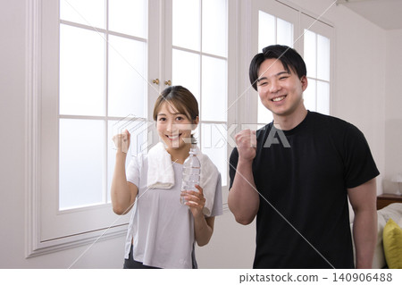 Smiling young woman talking to her personal trainer Smiling young woman talking to her personal trainer 140906488