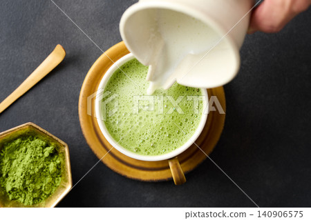 將抹茶拿鐵倒入杯中。 140906575