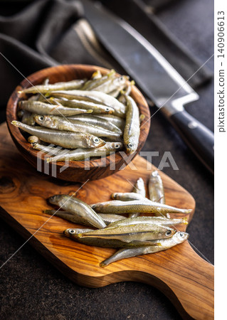 Fresh Small Fish On Wooden Board With Bowl Of Seafood Ready For Cooking Fresh Small Fish On Wooden Board With Bowl Of Seafood Ready For Cooking 140906613