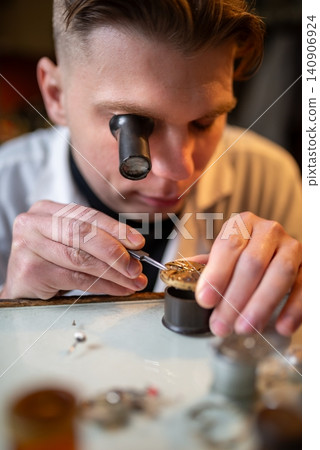 Watchmaker repairing mechanical watch movement under magnifying loupe with precise tools Watchmaker repairing mechanical watch movement under magnifying loupe with precise tools 140906924