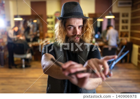 Barber posing with crossed arms holding scissors and straight razor Barber posing with crossed arms holding scissors and straight razor 140906978