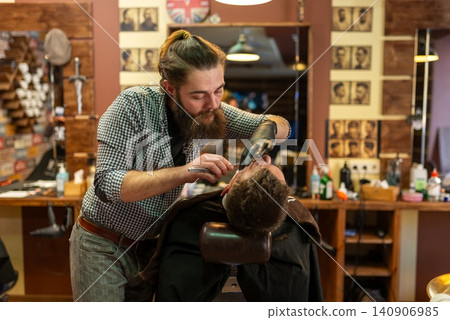 Straight razor trimming on customer face in the barbershop Straight razor trimming on customer face in the barbershop 140906985