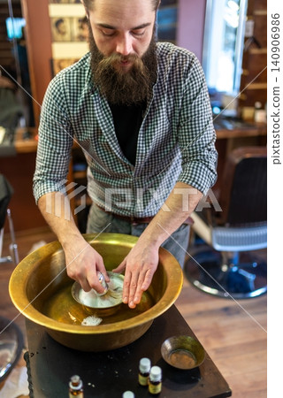 Barber preparing rich shaving foam in a traditional brass basin bowl Barber preparing rich shaving foam in a traditional brass basin bowl 140906986