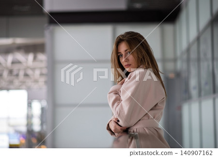 Woman standing on glazed balcony in airport. Woman standing on glazed balcony in airport. 140907162