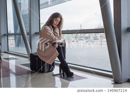 Passenger woman in airport waiting for air travel. Passenger woman in airport waiting for air travel. 140907214